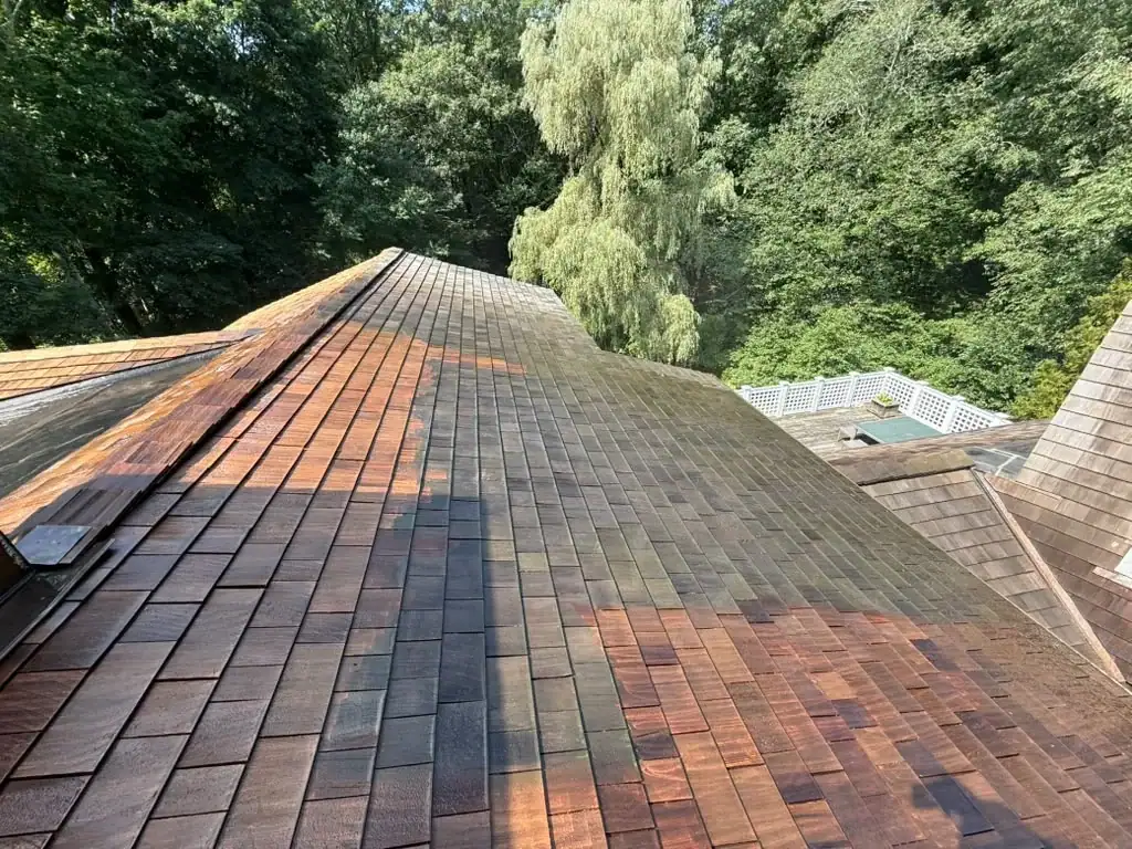 Cedar shakes wet during cleaning, showing treated and untreated areas