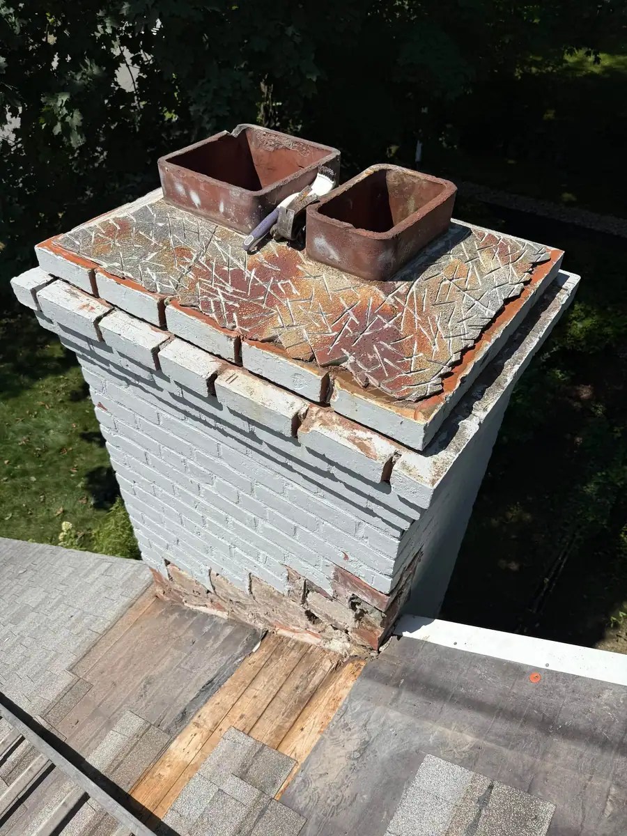 Chimney repair in progress with the crown opened and roof decking exposed