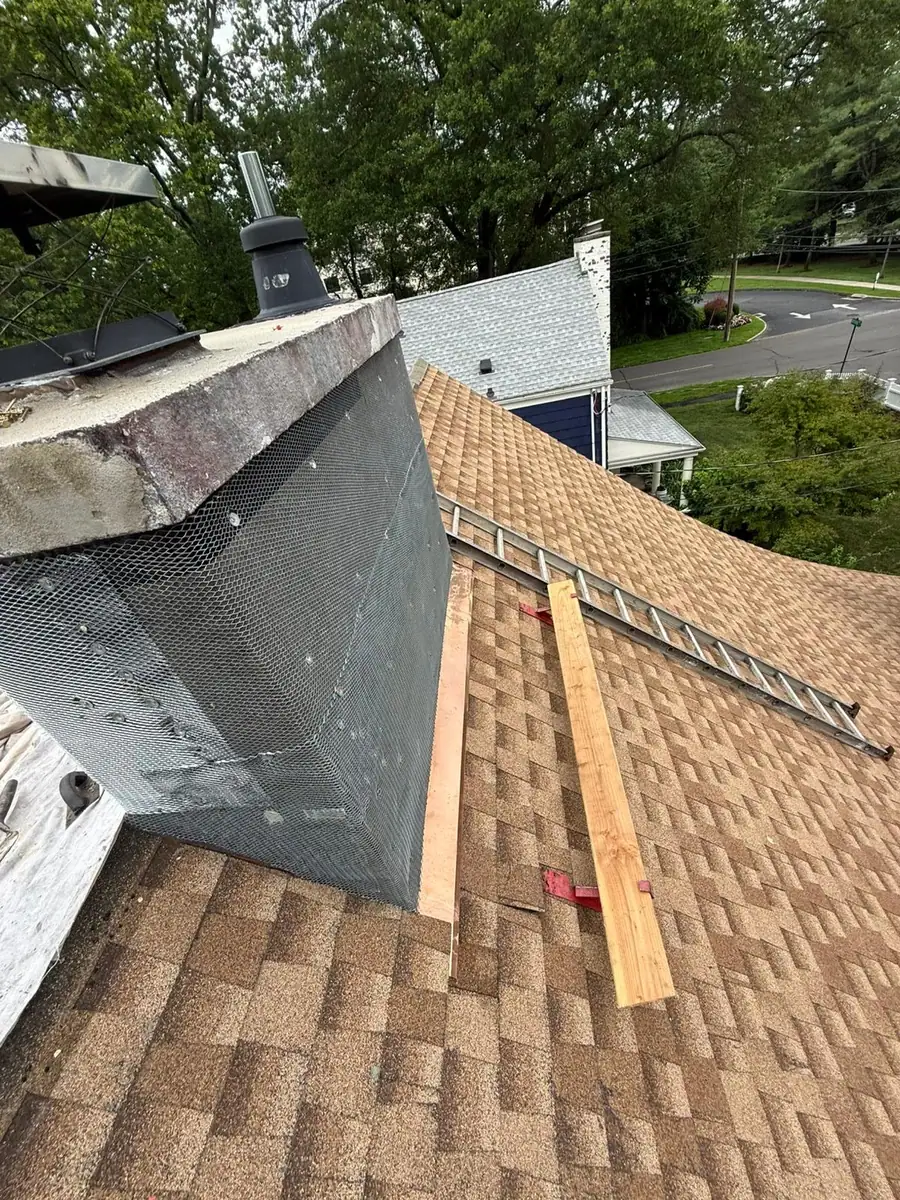 Copper flashing installed behind the stucco at the chimney roof transition